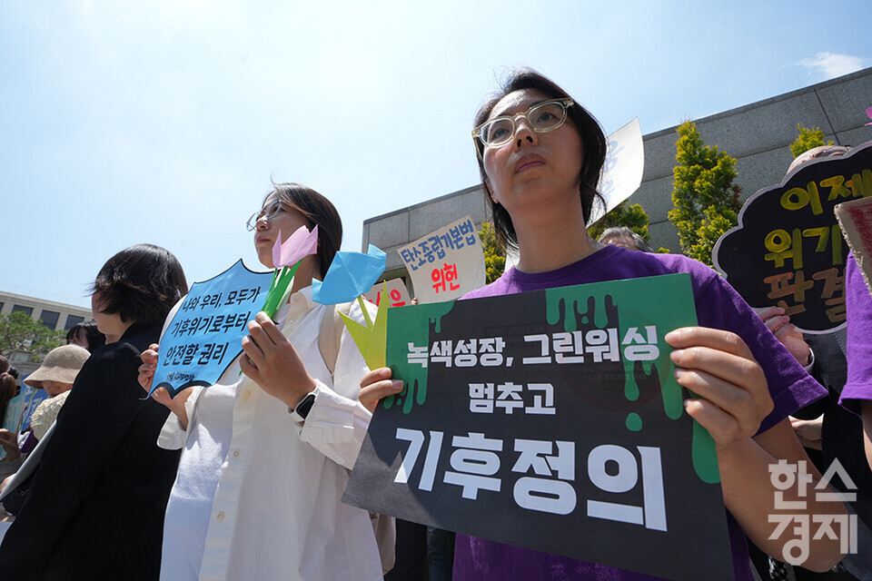 21일 오후 서울 종로구 헌법재판소 정문 앞에서 ‘희망'의 메리골드가 피어난 기후소송 2차 공개변론 기자회견이 열리고 있다. 참석자들이 손 피켓을 들고 있다. /최대성 기자 dpdaesung@sporbiz.co.kr 2024.05.21