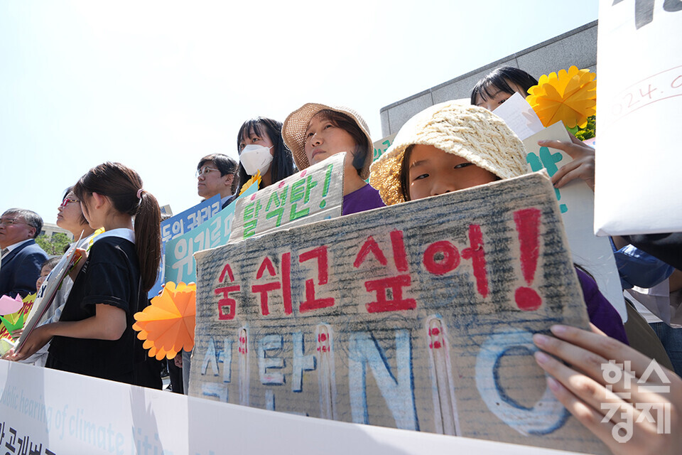 21일 오후 서울 종로구 헌법재판소 정문 앞에서 ‘희망'의 메리골드가 피어난 기후소송 2차 공개변론 기자회견이 열리고 있다. 참석자들이 손 피켓을 들고 있다. /최대성 기자 dpdaesung@sporbiz.co.kr 2024.05.21