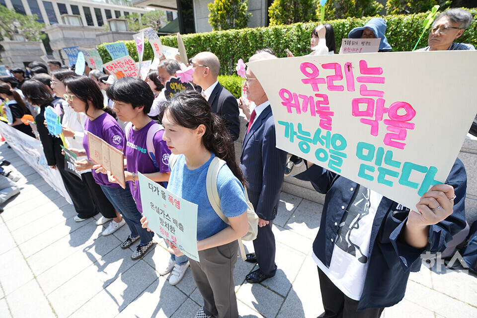 21일 오후 서울 종로구 헌법재판소 정문 앞에서 ‘희망'의 메리골드가 피어난 기후소송 2차 공개변론 기자회견이 열리고 있다. 참석자들이 손 피켓을 들고 있다. /최대성 기자 dpdaesung@sporbiz.co.kr 2024.05.21