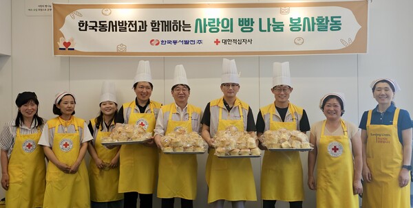 한국동서발전이 '사랑의 제빵' 봉사활동으로 임직원이 직접 머핀 200개를 만들어 복지시설에 전달했다. 봉사활동에 참석한 동서발전 직원과 관계자들이 직접 만든 머핀을 들고 기념사진을 촬영하는 모습 / 한국동서발전 제공