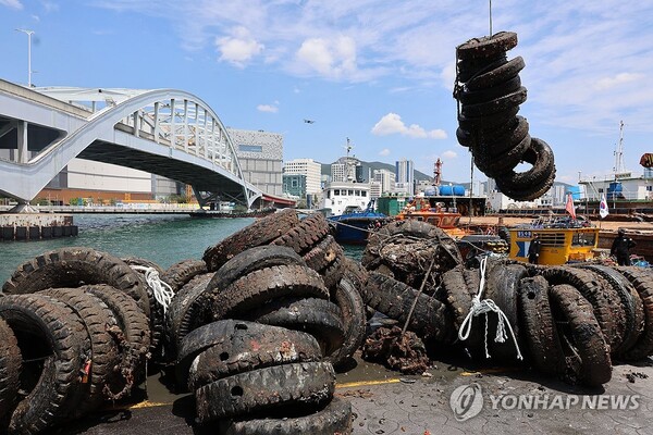산을 이룬 해양쓰레기 - 바다의 날을 앞둔 28일 오전 부산 영도구 봉래동 물량장에서 부산해경과 부산시, 한국해양구조협회 등이 바다 아래 잠겨 있던 폐타이어를 크레인으로 끌어 올리고 있다. 이날 해당 단체들은 98t가량의 해양 쓰레기를 수거했다. /연합뉴스