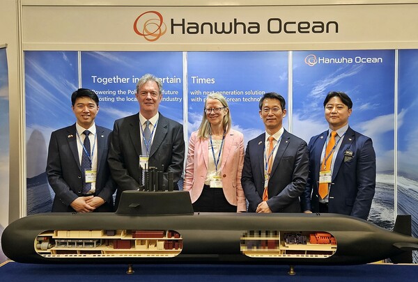 영국 밥콕 인터내셔널 국제 부문 총괄 닉 하인 경(왼쪽에서 두번째) , 폴란드 주재 영국 대사 안나 클룬즈(왼쪽에서 세번째)와 한화오션 정승균 특수선 해외사업단장(오른쪽에서 두번째) 등 관계자들이 지난 20일 폴란드 바르샤바에서 열린 국제 해양 안보 포럼에 참가, 한화오션이 별도 마련한 전시 부스를 방문해 기념촬영을 하는 모습. / 한화오션 제공