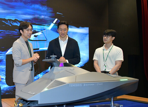 정기선 HD현대 부회장이 미래기술원 연구원들로부터 팔란티어와 공동개발 중인 무인수상정(USV) '테네브리스'에 대한 설명을 듣고 있다. / HD현대 제공