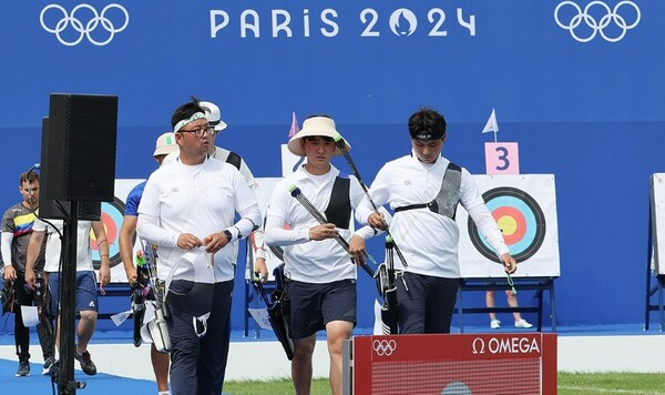 한국 양궁 대표팀의 김우진, 이우석, 김제덕(왼쪽부터 순서대로)이 점수 확인을 마친 뒤 사대로 향하고 있다. /연합뉴스
