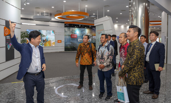 인도네시아 전력공사(PLN) 방문단이 한전KDN 홍보관을 방문해 설명을 듣고 있다. / 사진=한전KDN. 