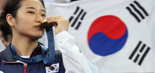 5일(현지시간) 프랑스 파리 포르트드 라 샤펠 아레나에서 열린 2024 파리올림픽 배드민턴 여자 단식 결승전에서 중국 허빙자오를 이기고 우승을 차지한 한국 안세영이 시상대에 올라 금메달이 입을 맞추고 있다. /연합뉴스