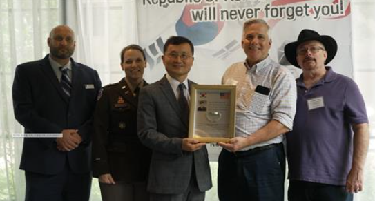 이근원 국방부유해발굴감식단장(가운데)이 16일(현지시각) 미국 버지니아주에서 고(故) 노만 네이헤이셀 미 육군 일병의 유가족을 만나 고인의 유품(팔찌형 인식표)을 전달하고 기념촬영을 하고 있다./ 연합뉴스 제공