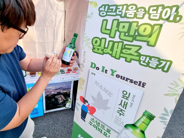 [이미지 1] 지난 29일까지 열린 국제남도음식문화큰잔치에서 관람객이 _나만의 잎새주_ 라벨 만들기 이벤트에 참여하고 있다. (사진=보해양조 제공)