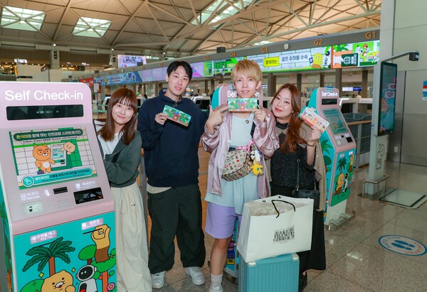 인천공항 제1여객터미널 내 셀프 체크인존에서 일본인 관광객이 셀프 체크인 후 카카오 캐릭터가 인쇄된 탑승권을 들고 기념촬영을 하고 있다. /인천공항공사 제공