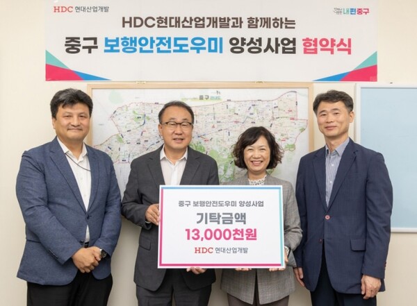 신왕섭 HDC현대산업개발 실장(왼쪽 두 번째)과 김남희 서울 중구청 경제문화국장(오른쪽 두 번째)이 16일 서울 중구청에서 보행안전도우미 양성을 위한 업무협약을 체결하고 기념촬영하고 있다./HDC현대산업개발 제공
