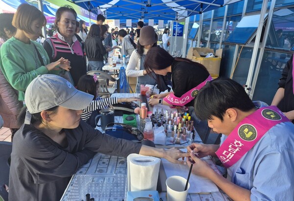 호남대 '미쁘다' 사회봉사단원들이 행사 참여 시민들께 네일아트를 해주고 있다. /호남대 제공