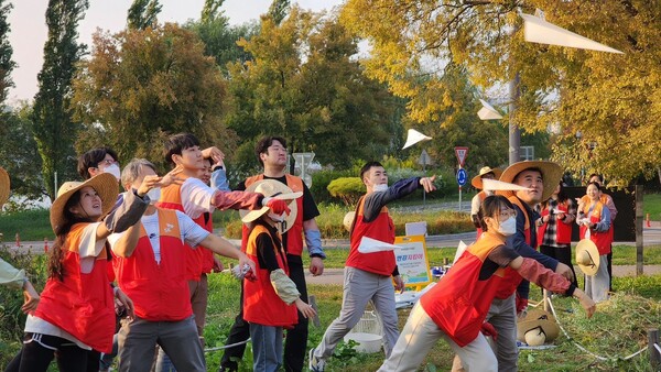 SK이노베이션 계열 구성원들이 물에 녹는 종이에 씨앗을 담은 ‘꽃씨 비행기’를 생태교란식물을 제거한 자리에 던지고 있다. / SK이노베이션