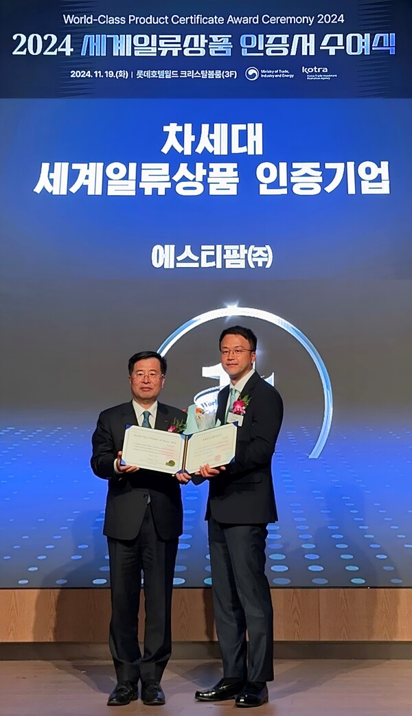에스티팜이 차세대 세계일류상품 생산기업으로 선정돼 인증서를 수여 받았다. KOTRA 강경성 사장(사진 왼쪽)과 에스티팜 김이환 상무(사진 오른쪽)./에스티팜 제공