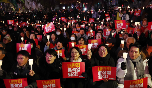 4일 오후 서울 동화면세점 앞에서 전국민주노동조합총연맹 주최로 열린 ‘내란죄 윤석열 퇴진! 시민촛불’에서 참가자들이 촛불을 들고 있다./ 연합뉴스