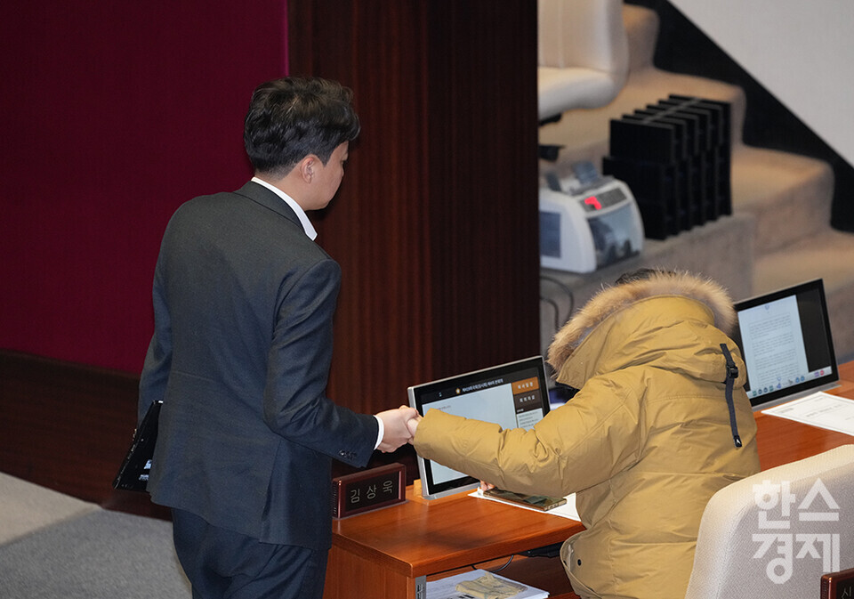 14일 오후 서울 여의도 국회 제419회 국회(임시회) 제4차 본회의에서 윤석열 대통령 탄핵소추안이 재석 300명 중 찬성 204명, 반대 85명, 기권 3명, 무효 8명으로 가결된 후 찬성표를 던진 국민의힘 김상욱 의원이 자리에서 일어나지 못하고 있다. 이에 개혁신당 이준석 의원이 가장 먼저 다가와 손을 잡아주고 있다. /최대성 기자 dpdaesung@sporbiz.co.kr 2024.12.14.