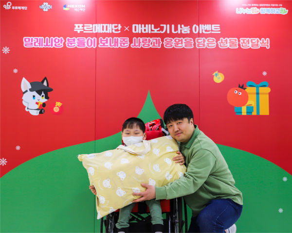선물 전달식에 참여한 민경훈 디렉터와 곽시현 어린이./넥슨재단