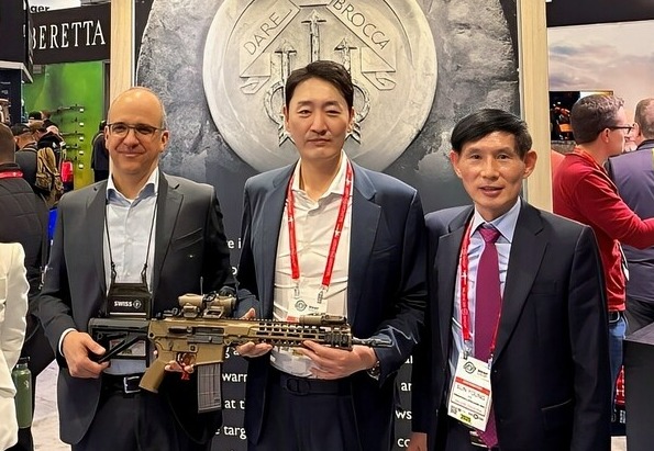 변성준 한컴그룹 부회장(가운데)과 김선영 한컴라이프케어 대표(오른쪽), 카를로 페를리토 베레타 회장(왼쪽)이 전시 부스에서 기념 사진을 촬영하고 있다./한컴