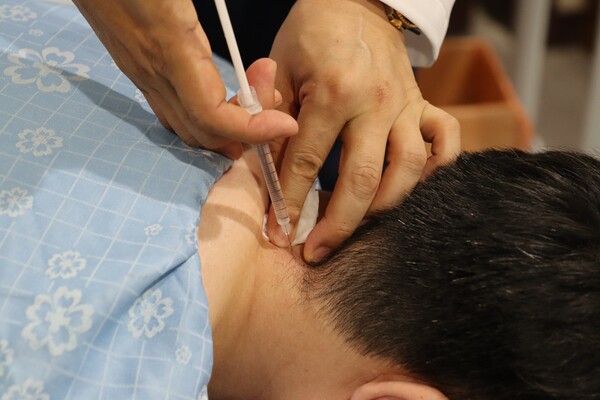 의료진이 목디스크 환자에게 약침 치료를 실시하고 있다./자생한방병원 제공