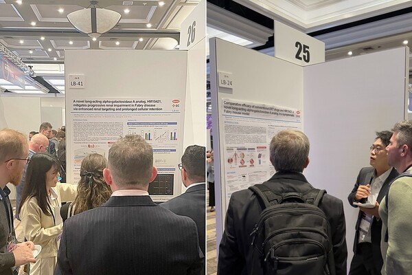 박초롱 한미약품 R&D센터 파트장(왼쪽)과 김원기 연구원(오른쪽)이 ‘월드 심포지엄 2025’에서 파브리병 치료제 ‘LA-GLA(코드명 : HM15421/GC1134A)’의 주요 연구 내용이 담긴 포스터를 토대로 참석자들에게 설명하고 있다. /한미약품 제공