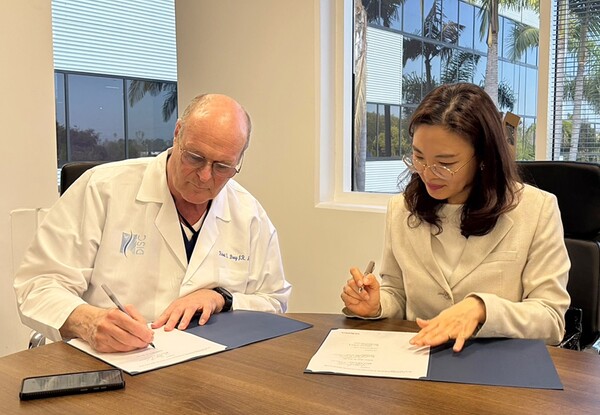 정주미 시지메드텍 대표(오른쪽)와 로버트 브레이 주니어 박사(Robert S. Bray, Jr.)가 최소 침습 척추 수술 기술 협력을 위한 계약서에 서명하고 있다./시지메드텍 제공