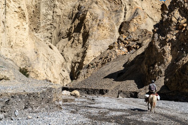 무스탕 원주민이 주요 이동 수단인 말을 타고 강 상류의 험한 계곡을 건너고 있다. 이 계곡 강변은 고생대 해저 생물인 암모나이트 화석이 많아 줍는 재미가 쏠쏠하다