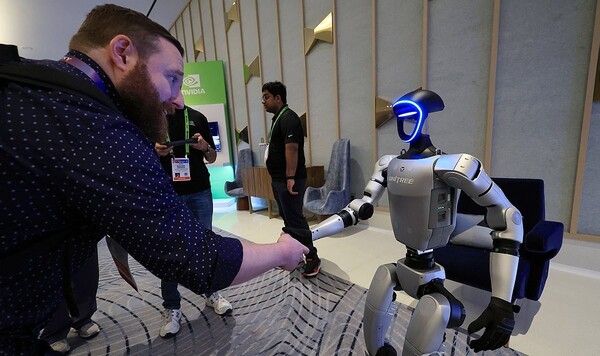세계 최대 가전·정보기술(IT) 전시회 CES 2025 개막인 지난 1월 7일 오전(현지시간) 젠슨 황 엔비디아 최고경영자(CEO) 글로벌 기자간담회가 열린 미국 네바다주 라스베이거스 퐁텐블루 호텔 엔비디아 전시관에서 휴머노이드 로봇 유니트리 G1이 관람객과 악수하고 있다. / 연합