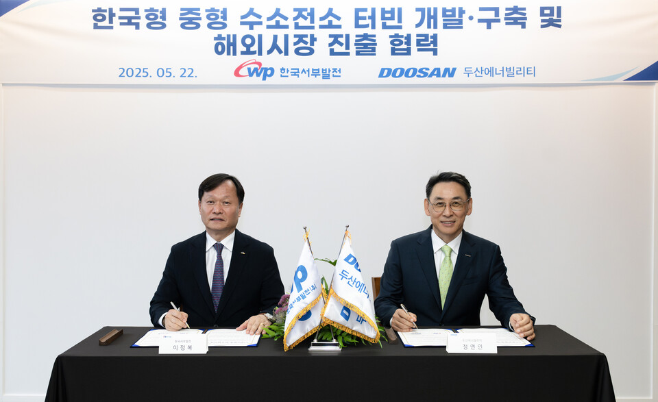 지난 22일 두산에너빌리티 창원 본사에서 진행된 한국형 중형 수소전소 터빈 개발·실증 양해각서 체결식에서 정연인 두산에너빌리티 부회장(오른쪽)과 이정복 한국서부발전 사장이 서명하고 있다./두산에너빌리티