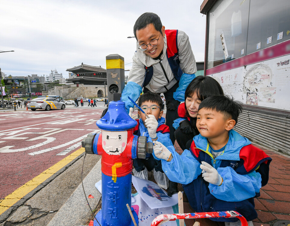 현대모비스 임직원과 가족들이 화재 예방과 시인성 향상을 위해 지상식 소화전에 도색 봉사활동을 하고 있다./현대모비스