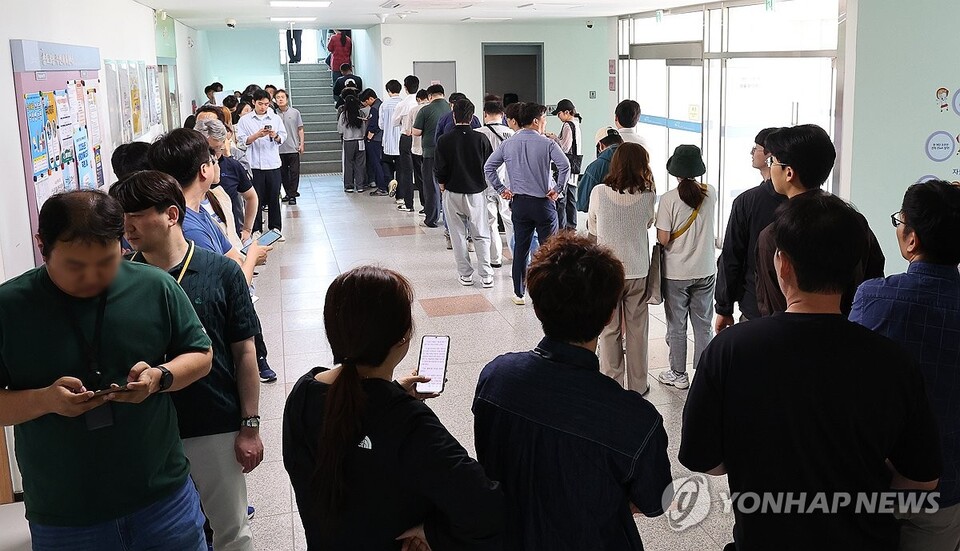 제21대 대통령선거 사전투표 첫날인 29일 인천 연수구 송도3동 행정복지센터에 마련된 사전투표소 앞에 직장인들이 점심시간을 이용해 투표하기 위해 길게 줄을 서 있다.  /연합뉴스