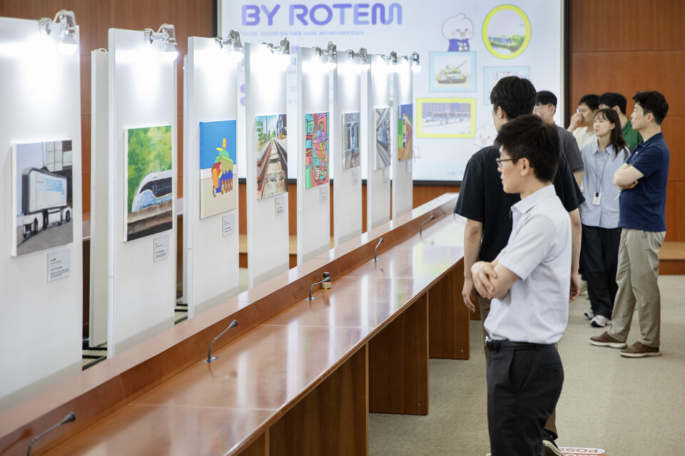 지난 12일 현대로템 임직원들이 의왕연구소에서 열린 장애인 미술작가 전시회를 관람하고 있다./현대로템