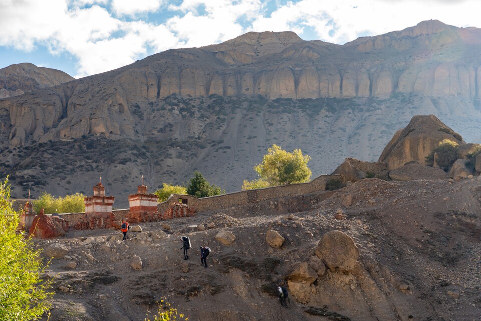 불탑이 있는 마을 뒤 가파른 산등성이를 오르는 트레커들.