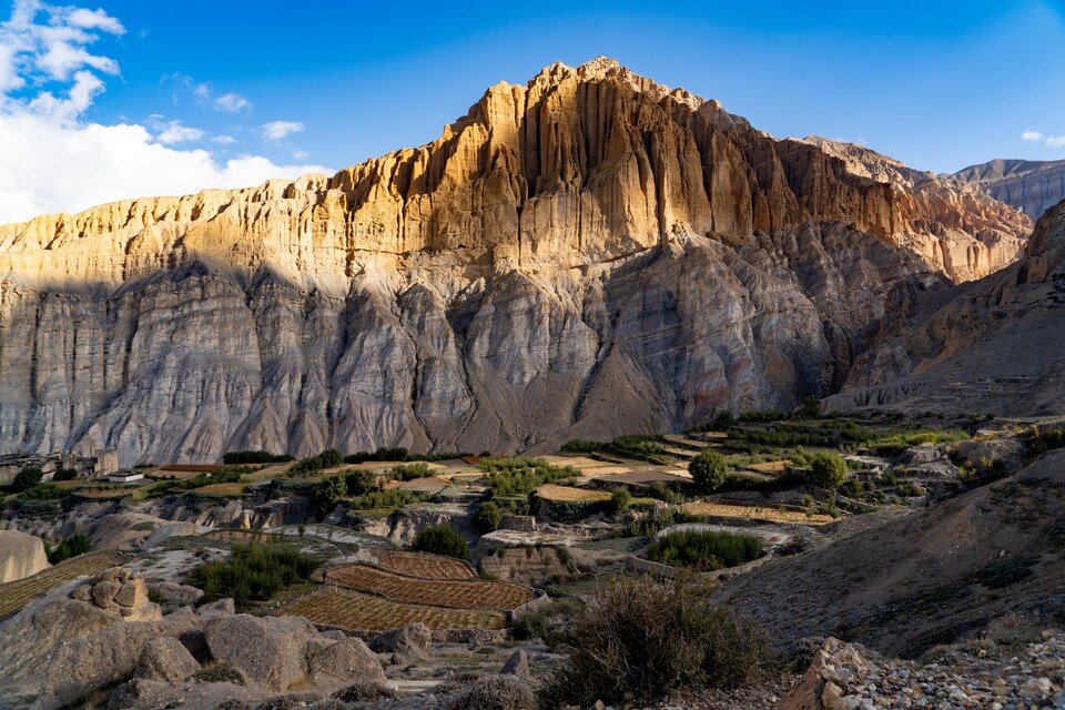 주황색의 거대한 암봉 아래 고즈넉하게 자리한 테탕마을과 초록의 밭.