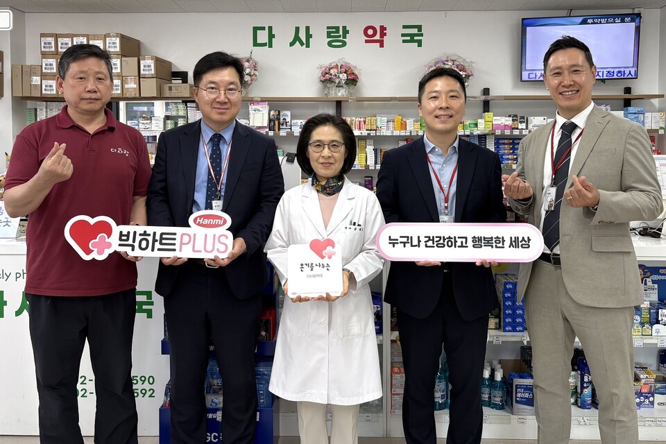 희귀질환을 앓고 있는 토성이의 사연을 소개한 서울 송파구 소재 다사랑약국 윤희정 약사(가운데)와 한미그룹 임직원들이 ‘빅하트PLUS’ 현판 전달식 후 기념촬영을 하고 있다. /한미그룹 제공
