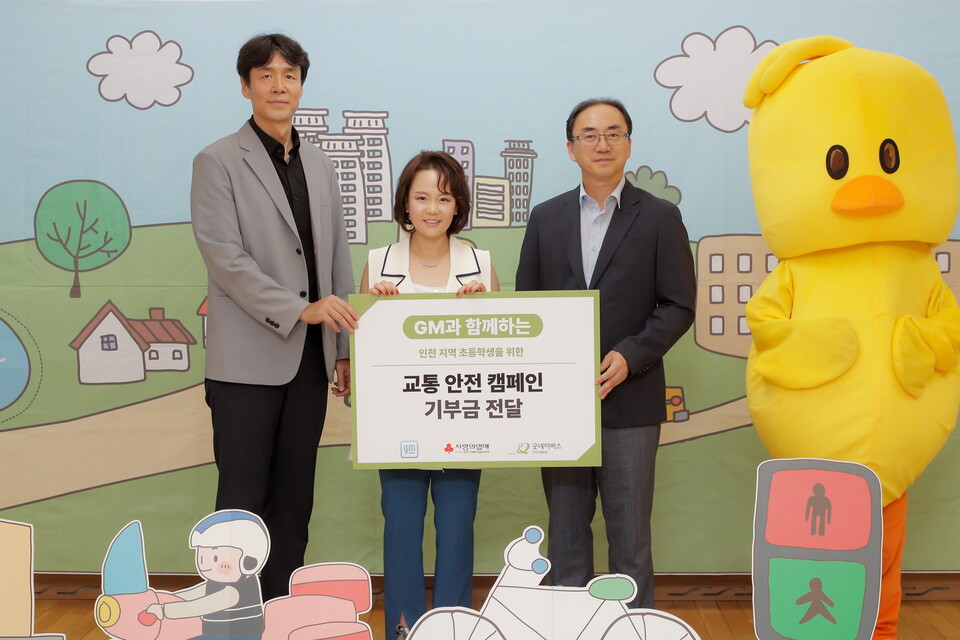 윤명옥 한국GM 최고마케팅책임자(CMO) 겸 커뮤니케이션 총괄 전무(가운데), 홍상진 굿네이버스 인천사업본부 본부장(왼쪽), 이지훈 명선초등학교 교장(오른쪽)이 인천 지역 초등학생을 위한 교통 안전 캠페인 기부금 전달식에서 기념 사진을 촬영하고 있다./한국GM