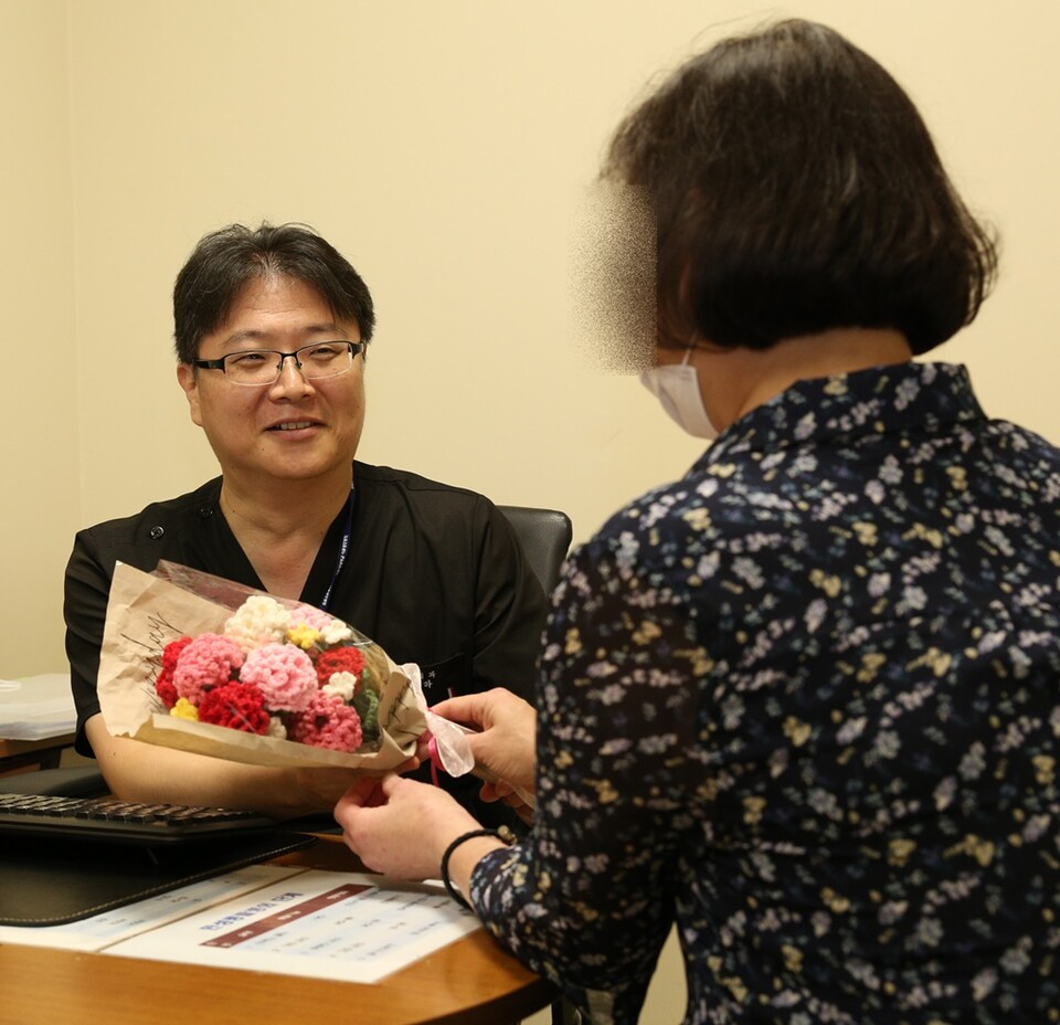 50대 말기 신부전 환자가 고도 감작으로 재이식이 어려운 힘든 상황을 이겨내고 두 번째 신장이식 수술로 건강을 되찾고, 정병하 서울성모병원 신장내과 교수에게 뜨개질로 만든 카네이션 꽃다발을 전하고 있다./서울성모병원 제공