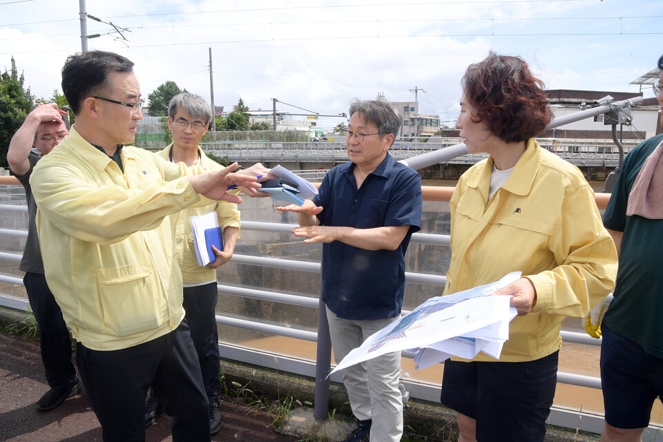 강기정 광주광역시장이 19일 폭우로 큰 피해를 입은 북구 신안교 일원을 찾아 피해상황을 살펴본 뒤에 관계부서에 빠른 복구 지원을 재차 지시하고, 근본적인 재발방지 대책 마련을 위해 방안을 논의하고 있다./사진=광주광역시