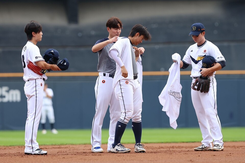 김재호(왼쪽 두 번째)가 지난 6일 은퇴 경기를 마친 뒤 박준순(왼쪽 세 번째)에게 등번호 52 유니폼을 물려주고 있다. /두산 베어스 제공