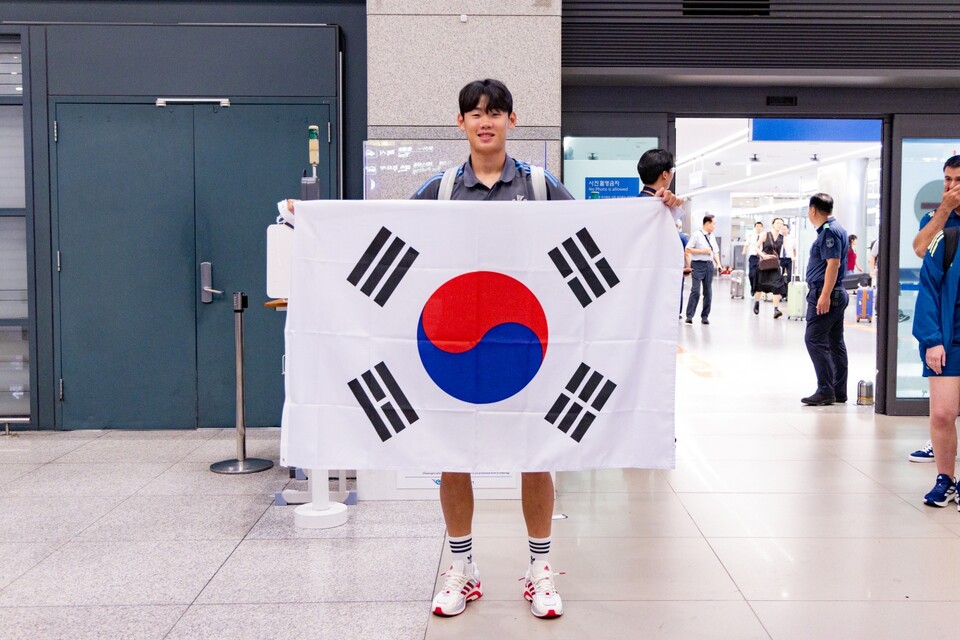 박승수가 입국장에서 태극기를 펼쳐들고 있다. /쿠팡플레이 제공