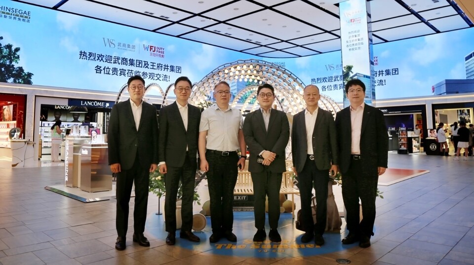 (왼쪽부터) 곽종우 신세계디에프 마케팅 담당, 양호진 전무, 판홍샹 우상그룹 동사장, 문현규 상무, 후용 왕푸징그룹 부총재, 윤기섭 코트라 우한무역관장이 신세계면세점 명동점 10층 아이코닉존 미디어파사드 앞에서 기념촬영 하고 있다. / 신세계면세점 제공