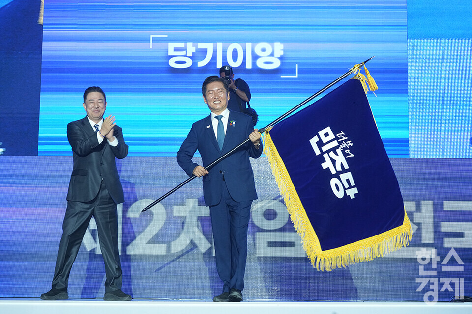 정청래 더불어민주당 신임 당 대표가 2일 오후 경기도 고양시 킨텍스에서 열린 더불어민주당 제2차 임시전국당원대회에서 당기를 이양받고 있다. /최대성 기자 dpdaesung@sporbiz.co.kr 2025.08.02.