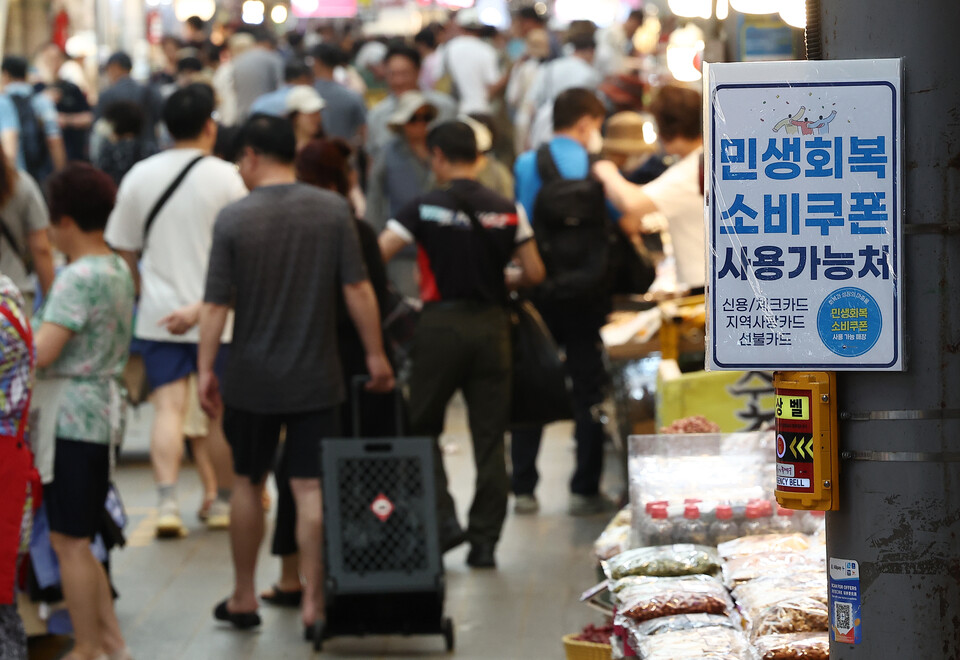 민생회복 소비쿠폰 지급 후 첫 주말인 지난달 27일 서울 동대문구 청량리 종합시장 한 가게에 쿠폰 사용이 가능하다는 안내문이 붙어 있다./연합뉴스