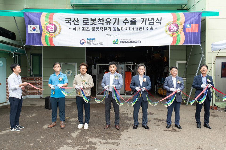 농촌진흥청 국립축산과학원 임기순 원장과 관계자들이 지난 6일 인천 서구에 위치한 (주)다운 본사에서 국산 로봇착유기 대만 수출 행사에서 테이프커팅을 하고 있다. /사진=농촌진흥청