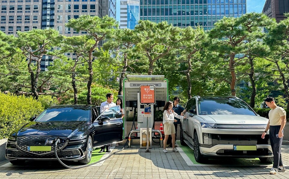 SK이노베이션 계열 직원들이 서울 종로구 SK서린빌딩에서 충전중인 현대자동차 대표 전기차 모델 아이오닉9과 eG80(전기화 모델)을 체험하고 있다./ SK이노베이션 제공