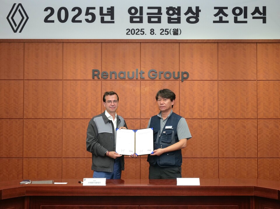 스테판 드블레즈 르노코리아  사장(왼쪽)과 박종규 노동조합 위원장이 25일 부산공장에서 열린 '2025년 임금협상 조인식'에서 합의안에 서명 후 기념 촬영을 하고 있다./르노코리아