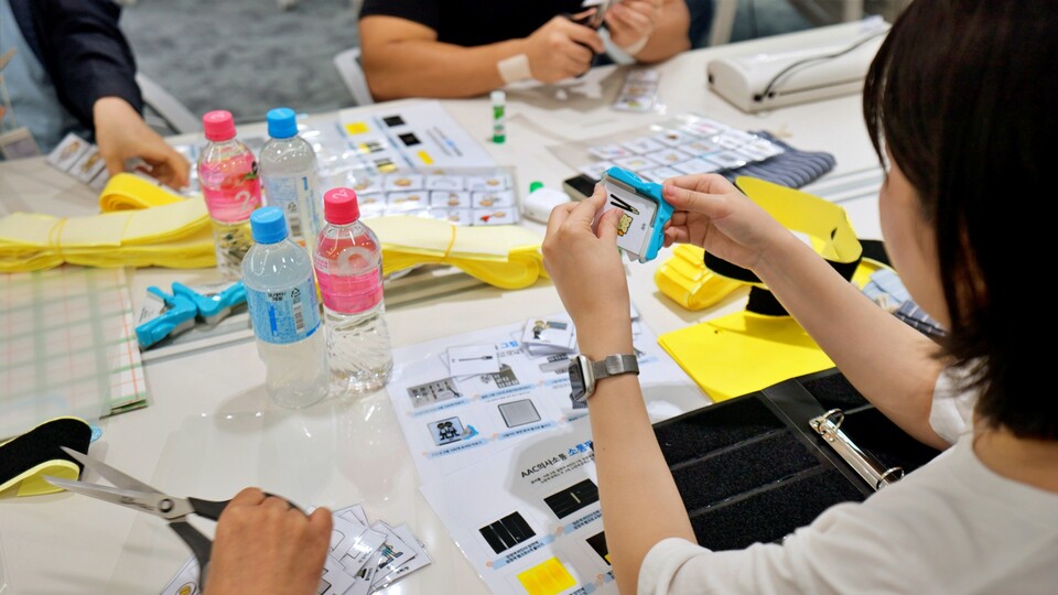 고려아연과 계열사 서린정보기술, 케이지트레이딩 임직원들이 언어장애 아동 재활치료용 교구 'AAC 의사소통판'을 제작하고 있다./고려아연