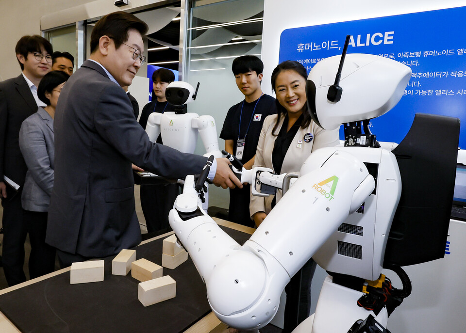 이재명 대통령이 17일 경기도 성남시 스타트업 스퀘어에서 컵 쌓기 퍼포먼스를 선보인 휴머노이드 로봇과 악수를 하고 있다. 사진=연합뉴스