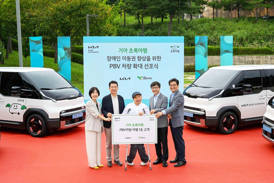 기아 이덕현 지속가능경영실장 이덕현 (왼쪽 첫번째), 이재강 사단법인 그린라이트 회장(오른쪽 첫번째) 등 주요 관계자들이 PV5 여행 1호 고객과 기념 촬영을 하고 있다./기아