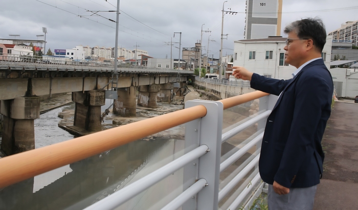 김대원 더민주전국혁신회의 광주북구 상임대표가 신안교 일대 침수 피해의 주요 요인으로 지목되는 신안철교 교각을 살피고 있다. /사진=신홍관 기자