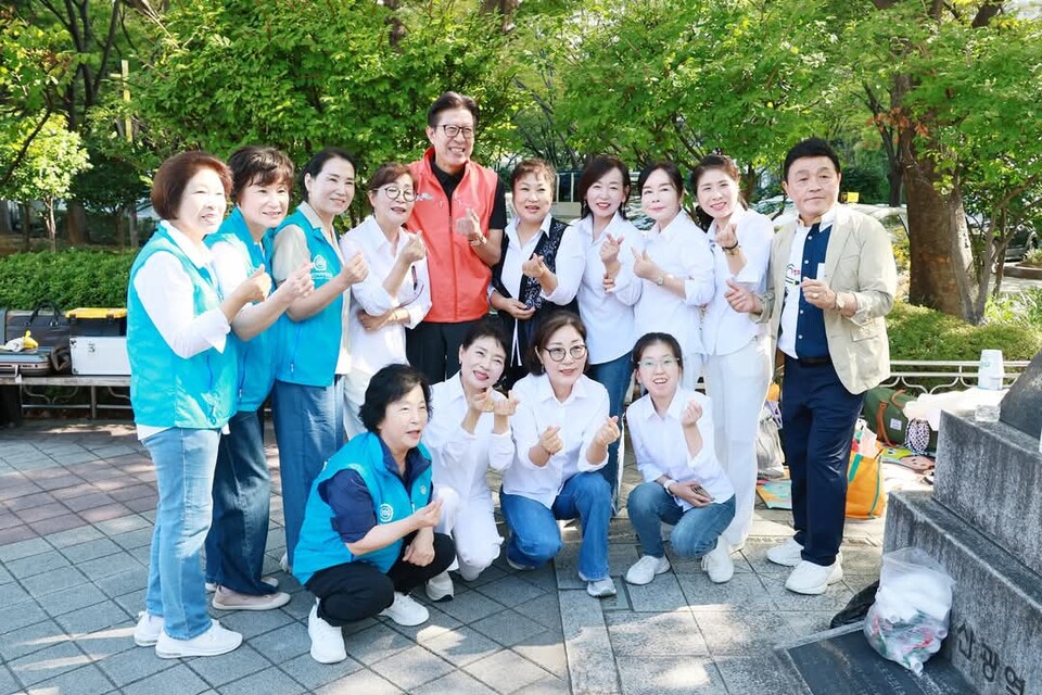 박형준 부산시장(붉은 조끼)이 11일 낮, 시청 뒤뜰 녹음광장에서 부산밥퍼나눔에 참여한 봉사자들과 함께 기념 촬영을 하고 있다. SNS(박형준) 캡처=이승렬 기자