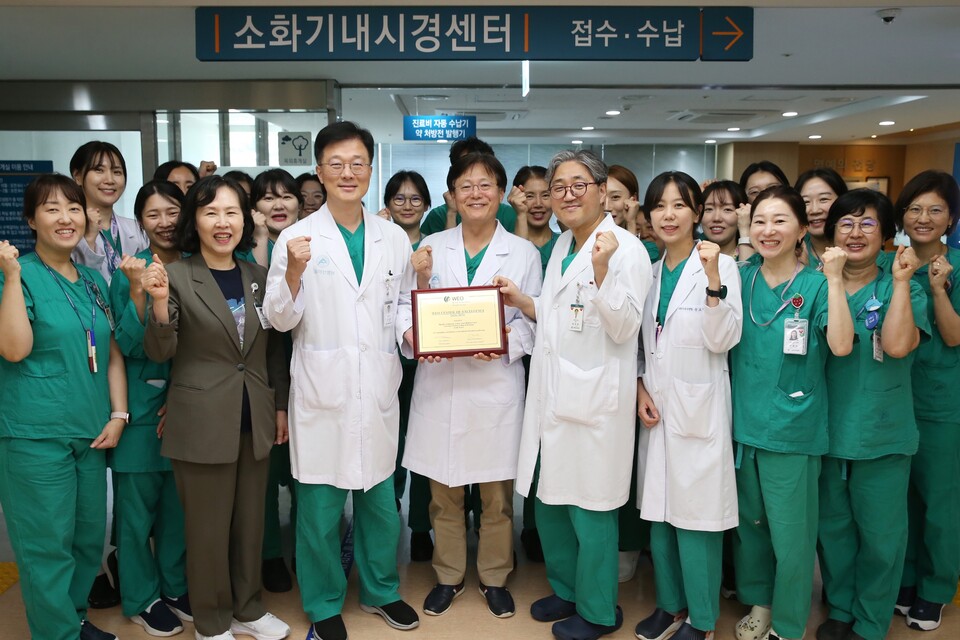 서울아산병원 소화기내시경센터 의료진이 세계내시경협회 '최우수 내시경센터' 인증패를 들고 기념촬영을 하고 있다./서울아산병원 제공